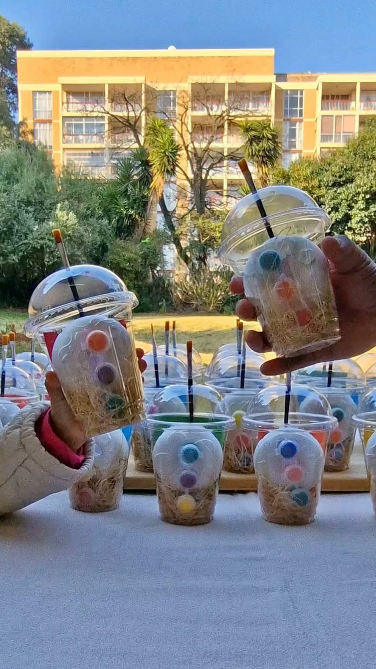 Clear plastic cups filled with shredded paper and colorful candy Easter eggs.