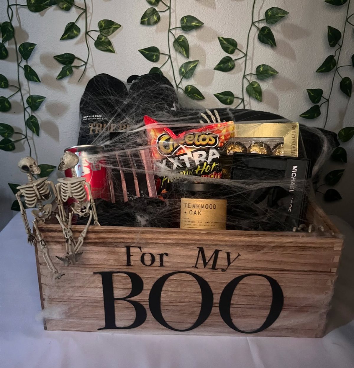 Halloween themed gift crate with snacks, socks, and skeletons for a boyfriend.