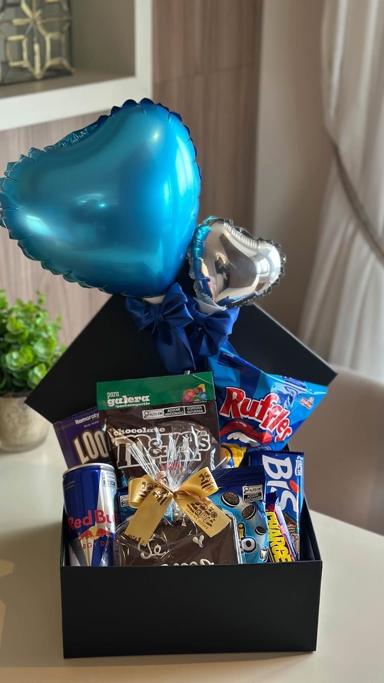 Black gift box filled with candy and blue heart-shaped balloons for a boyfriend.