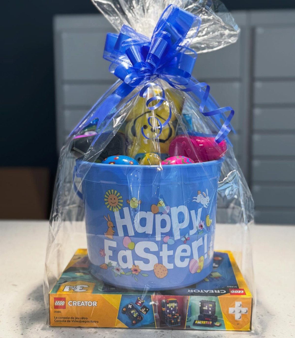 Easter basket with blue bucket and treats sitting on a LEGO gaming set box