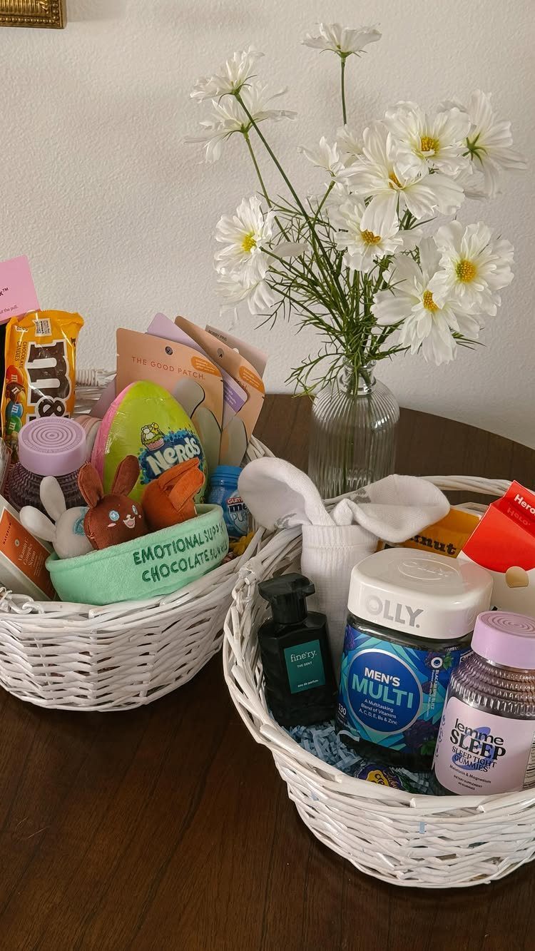 Two white wicker Easter baskets filled with snacks and grooming products on a table.