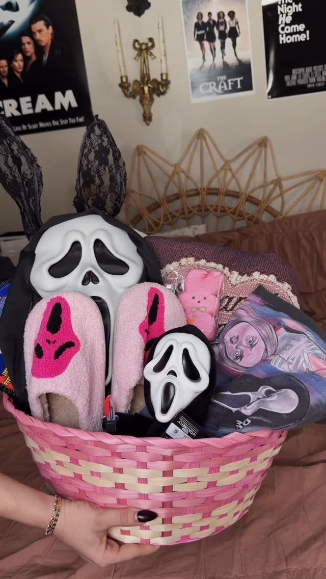 Pink woven basket filled with Scream movie themed mask, slippers, and apparel.