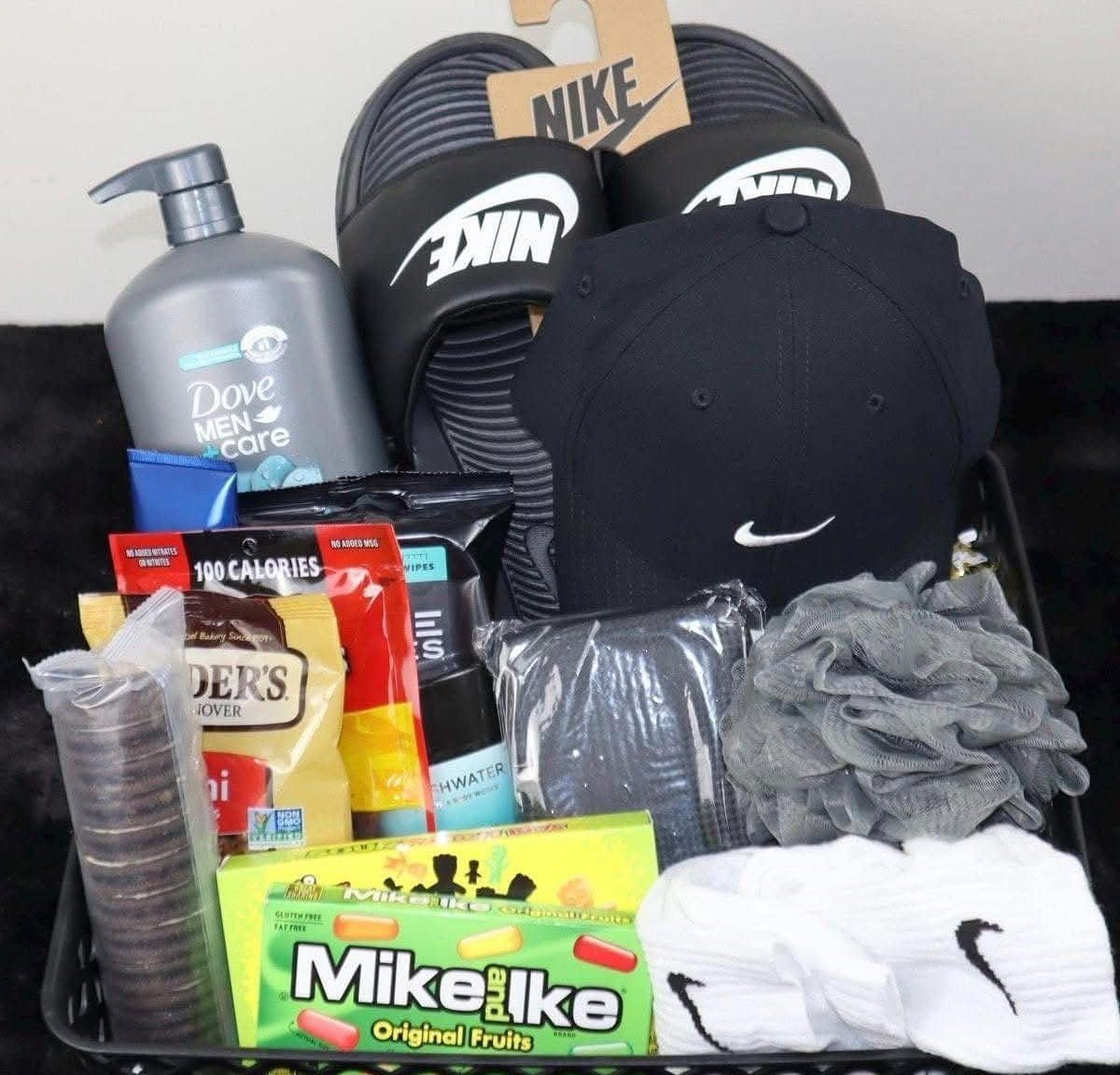 Gift basket containing Nike slides, a black cap, Dove body wash, and candy.