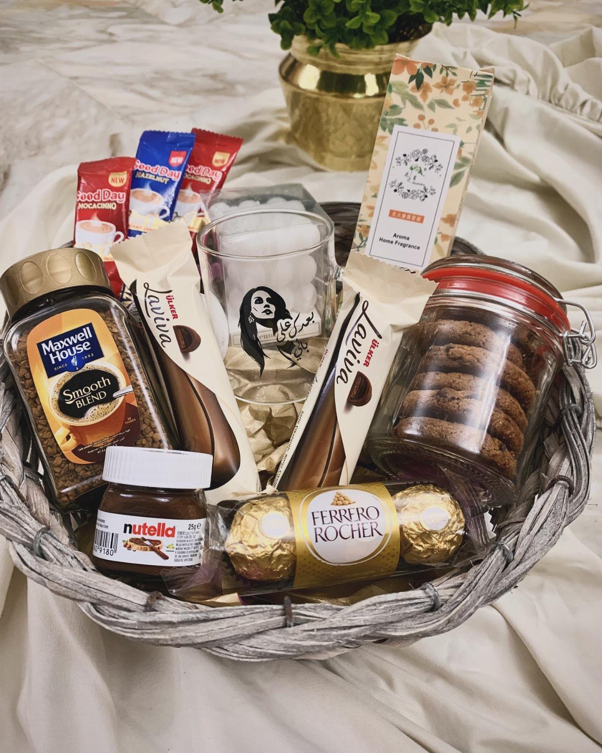 Coffee lover gift basket with Maxwell House coffee, chocolates, cookies, and a glass.