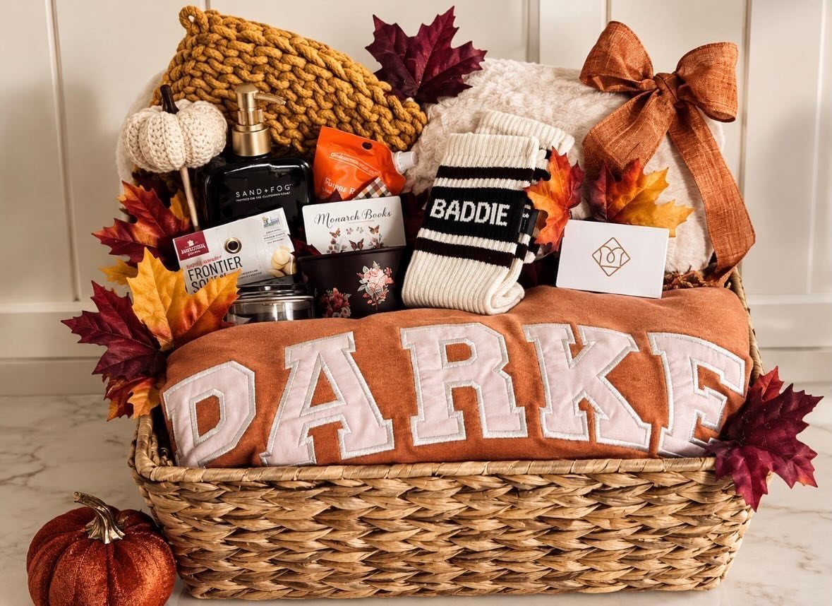 Woven gift basket filled with autumn apparel, skincare, and cozy Halloween themed accessories.