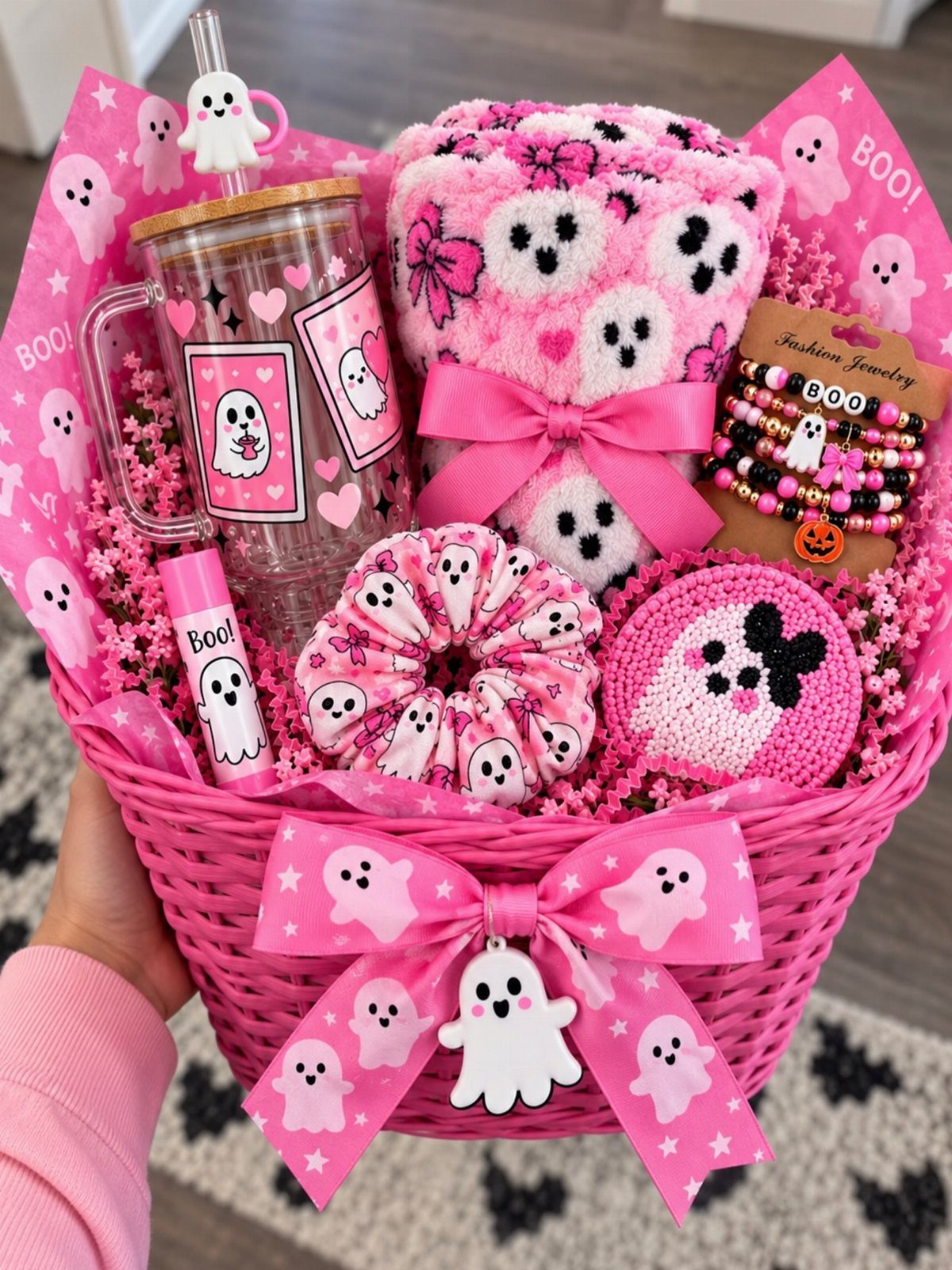 Pink Halloween boo basket filled with ghost-themed tumbler, socks, scrunchie, and jewelry.