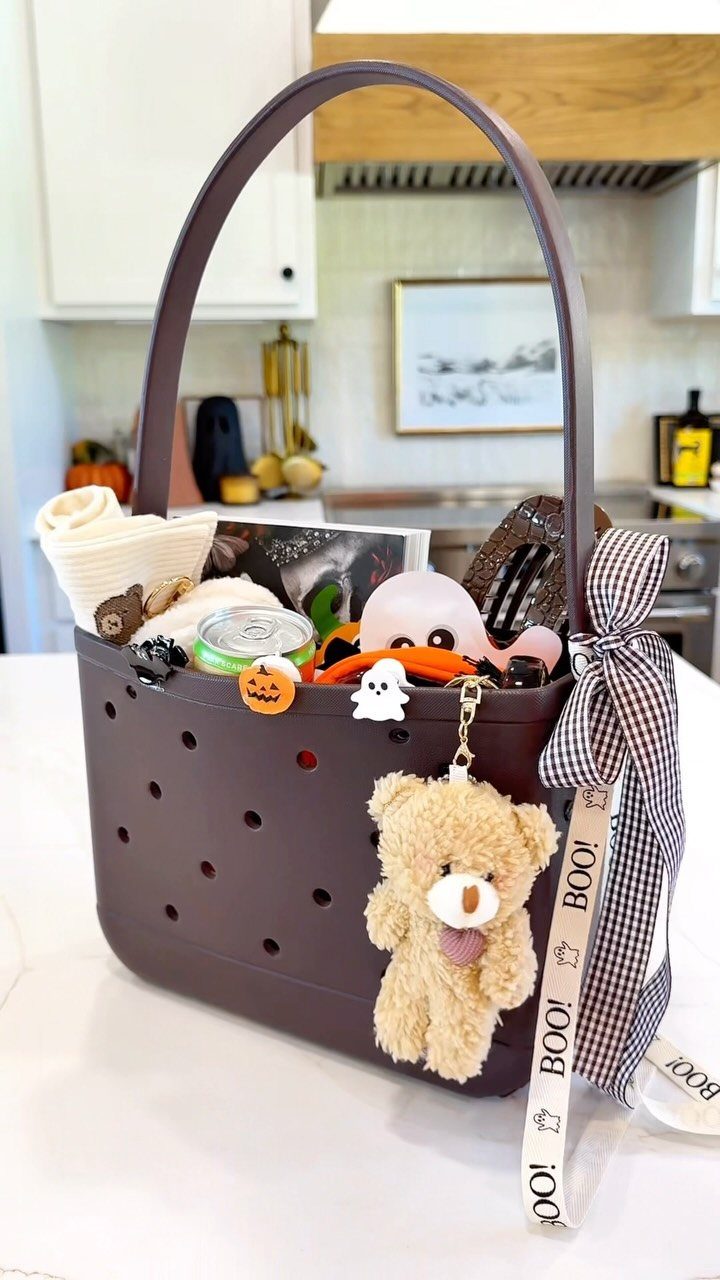 Purple Halloween gift basket filled with treats and a teddy bear keychain