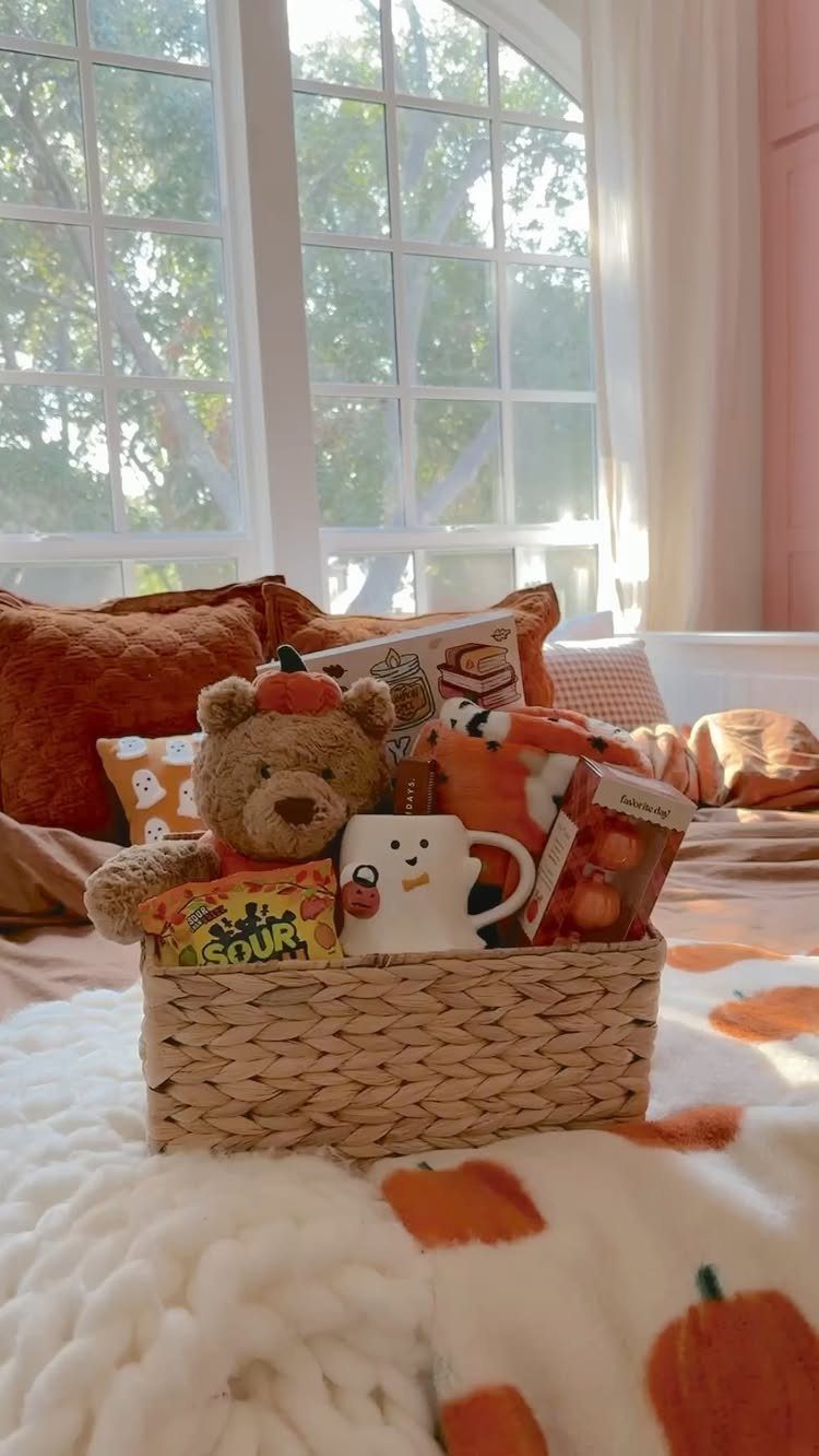 Woven gift basket with teddy bear and autumn treats on a pumpkin blanket