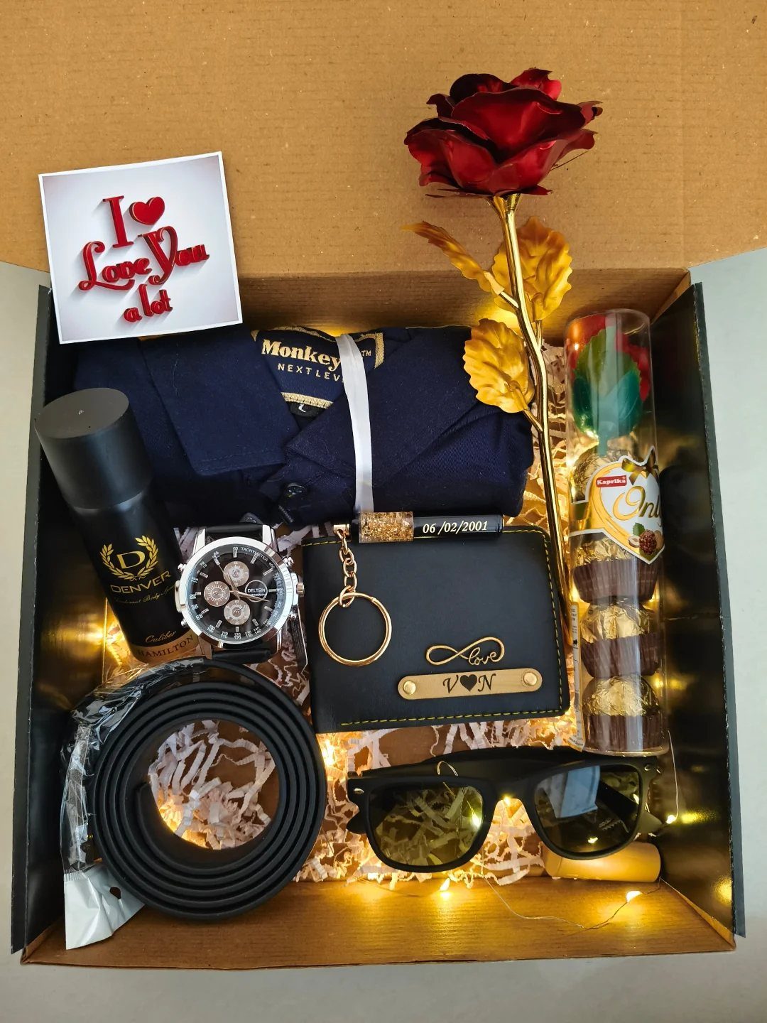 Gift box for men with shirt, watch, wallet, belt, sunglasses, and red rose.