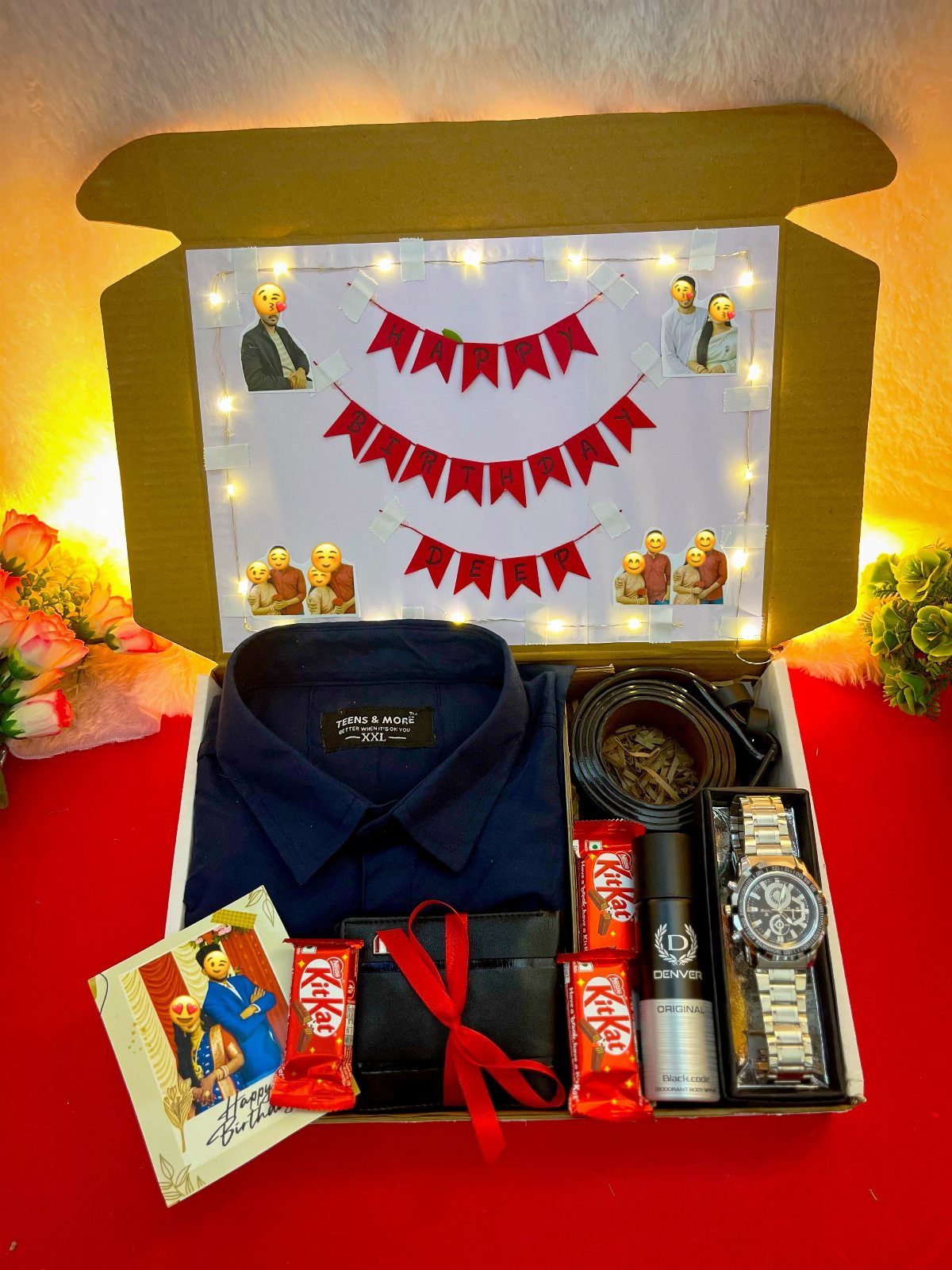 Gift box with navy shirt, watch, wallet, and chocolates decorated with fairy lights