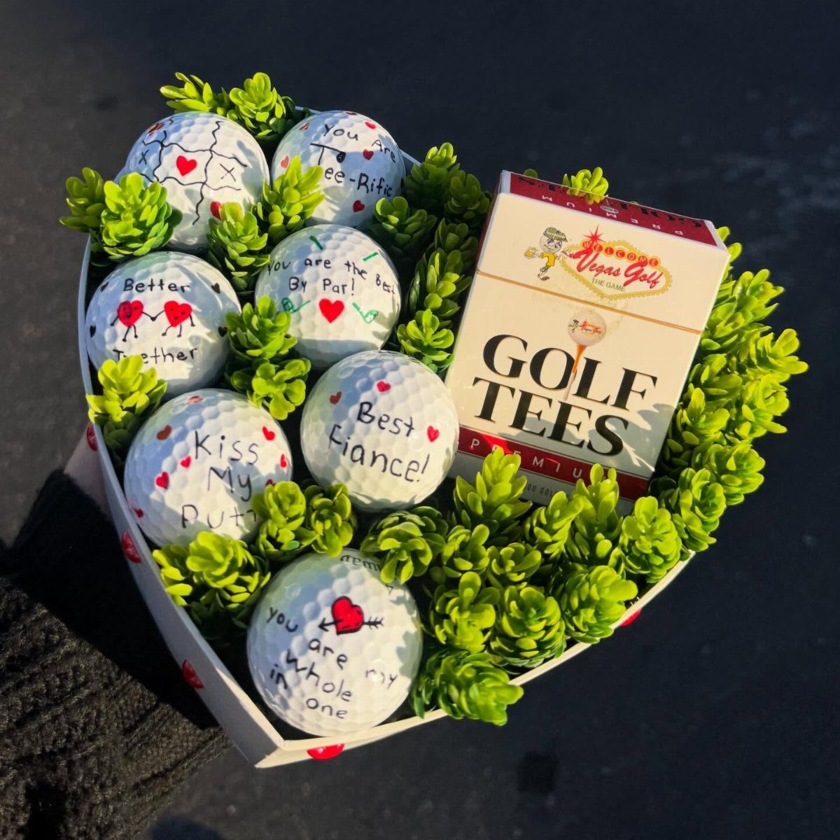 Heart-shaped gift basket with romantic golf balls and a box of golf tees.