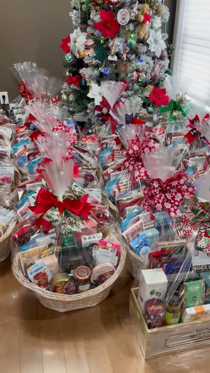 Gift baskets filled with assorted snacks wrapped in cellophane with red bows.