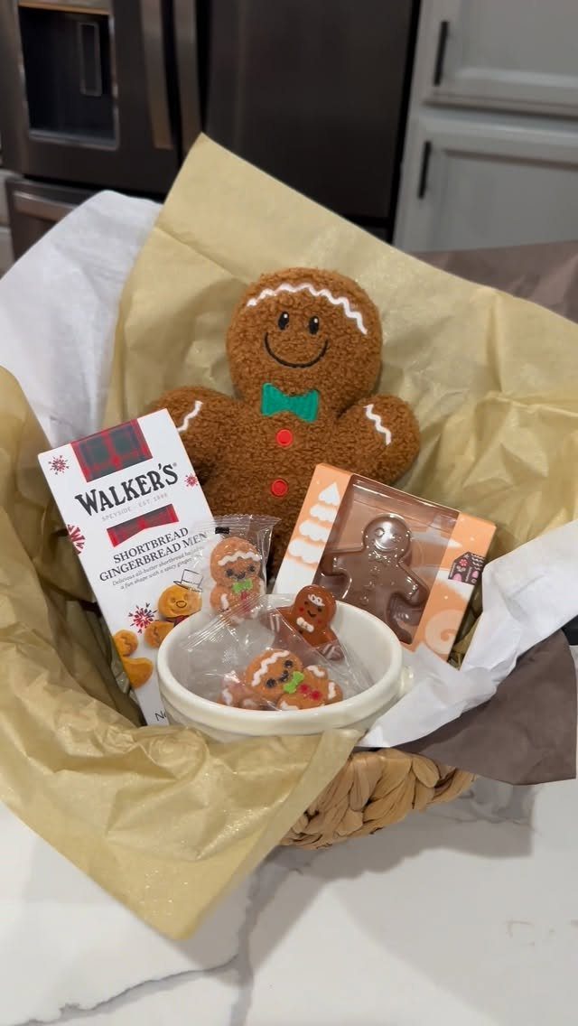 Gingerbread cookies and a plush gingerbread man in a gold lined gift basket.