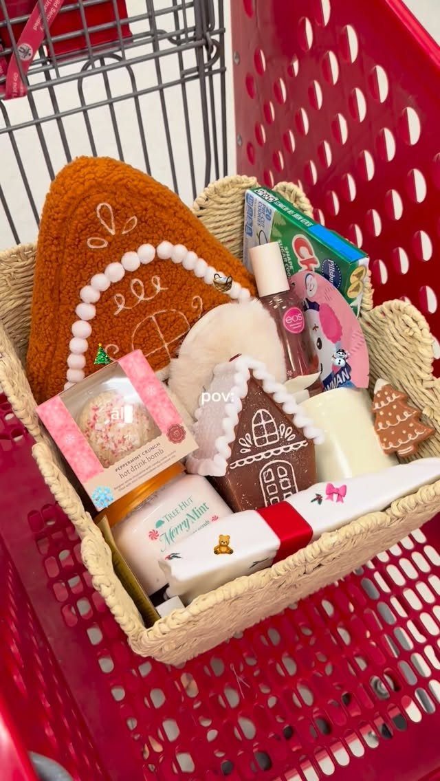 Woven gift basket in a red cart containing gingerbread plush and holiday treats.