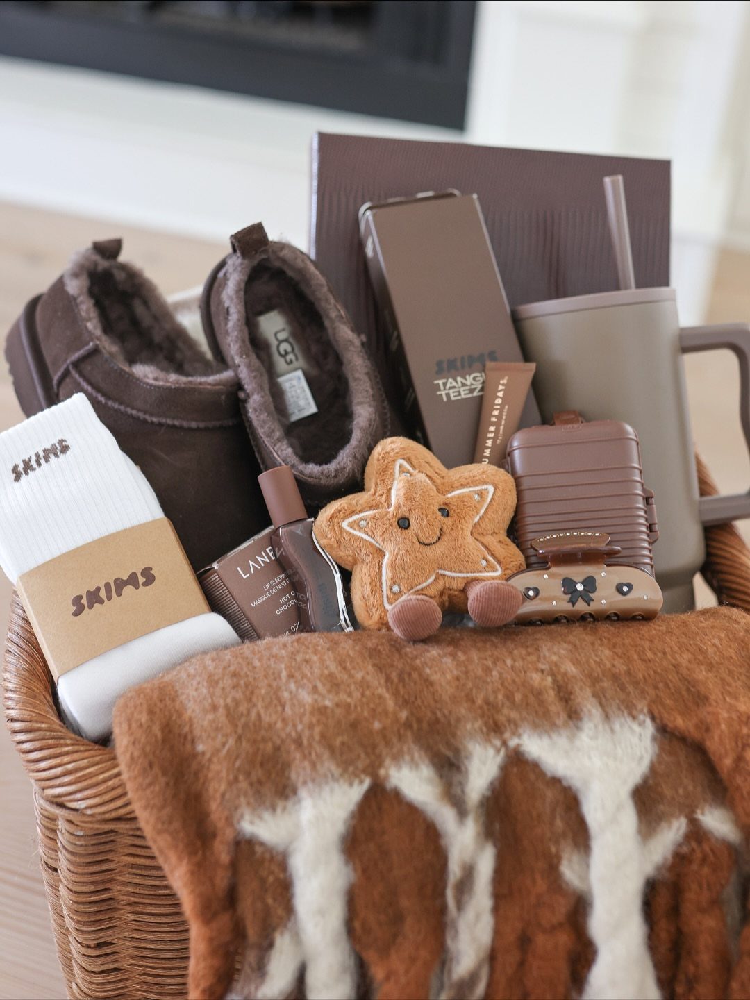 Woven wicker gift basket filled with brown winter accessories and a gingerbread plush.