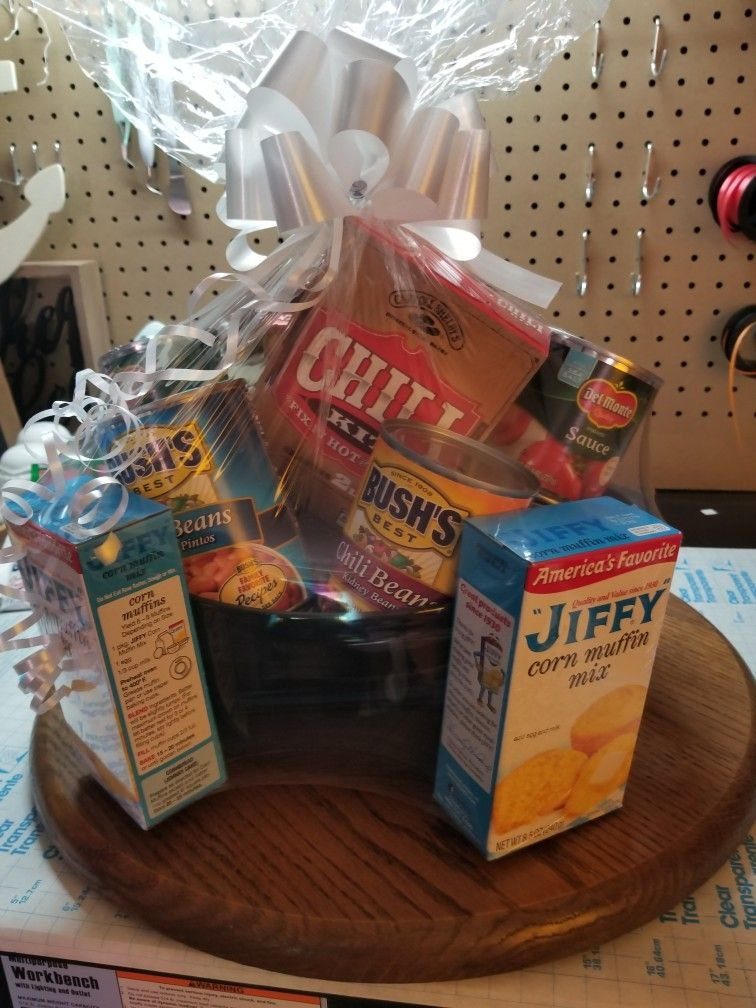 Gift basket with chili, beans, and corn muffin mix wrapped in cellophane.