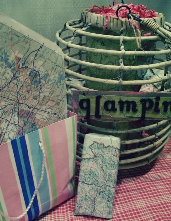 Glamper gift basket with a glamping sign, maps, and a striped gift bag.