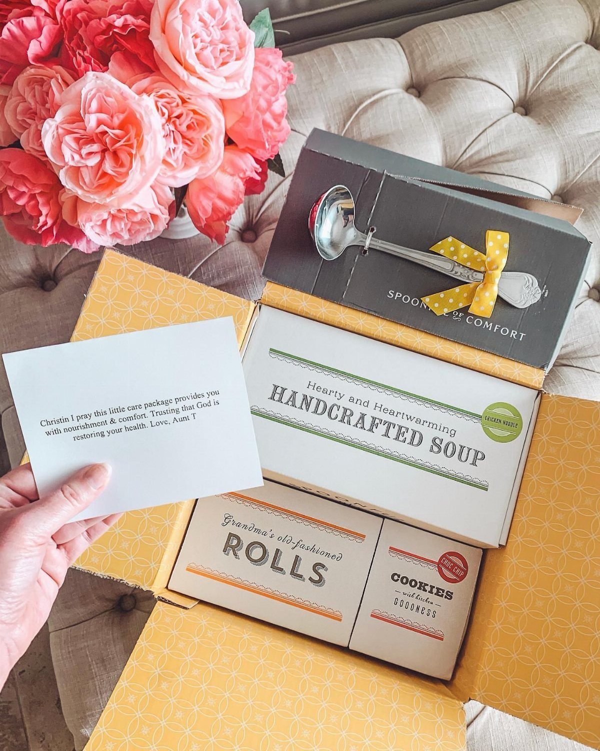 Care package box with handcrafted soup, rolls, cookies, and a handwritten note.