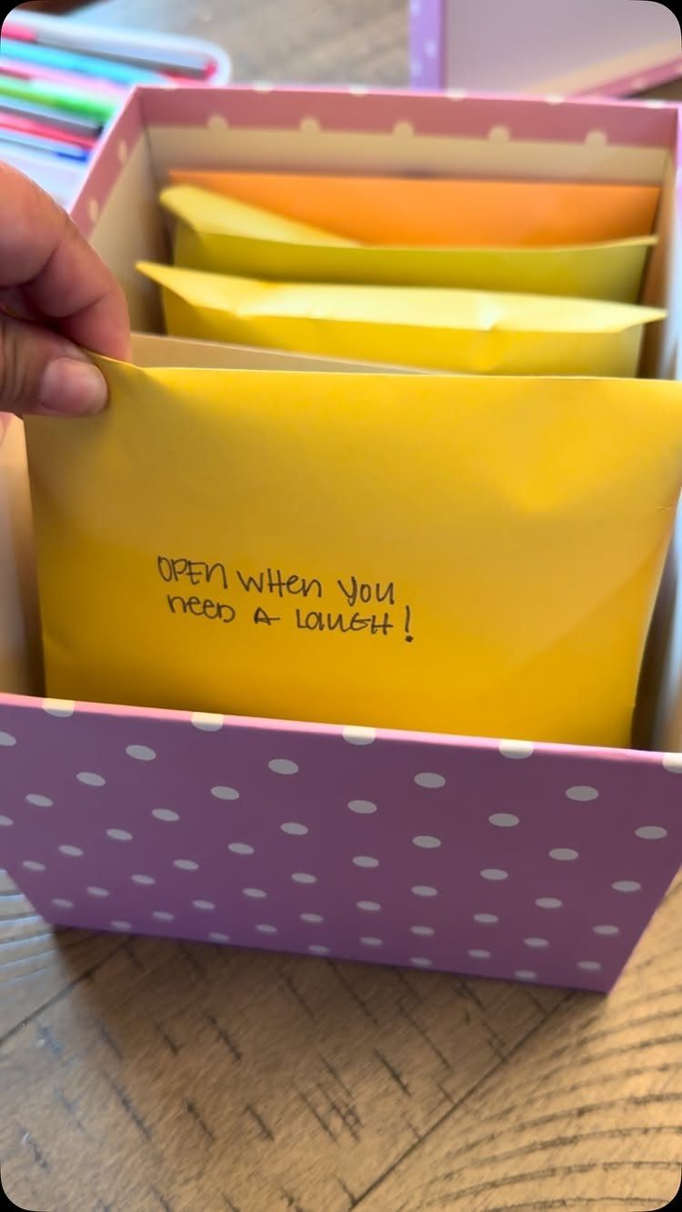 Hand pulling a yellow handwritten note from a purple polka-dot gift box