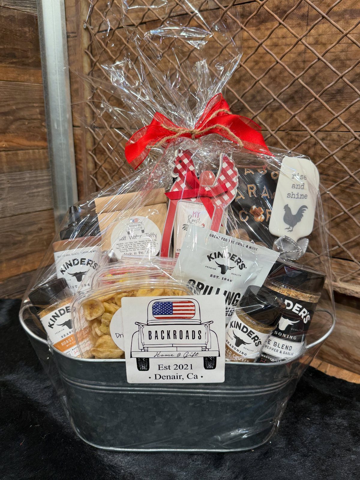 BBQ gift basket in a metal tub with seasonings and snacks wrapped in cellophane
