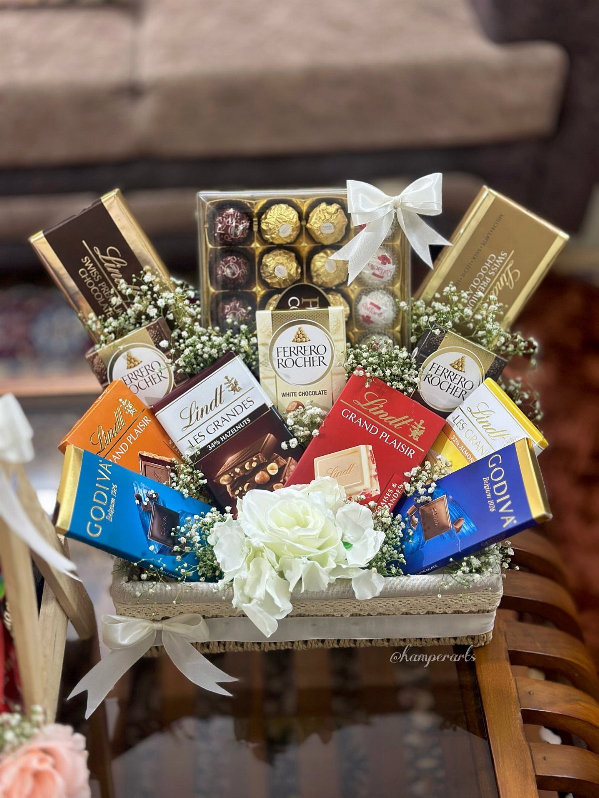 Chocolate gift basket with Lindt and Godiva bars decorated with white flowers