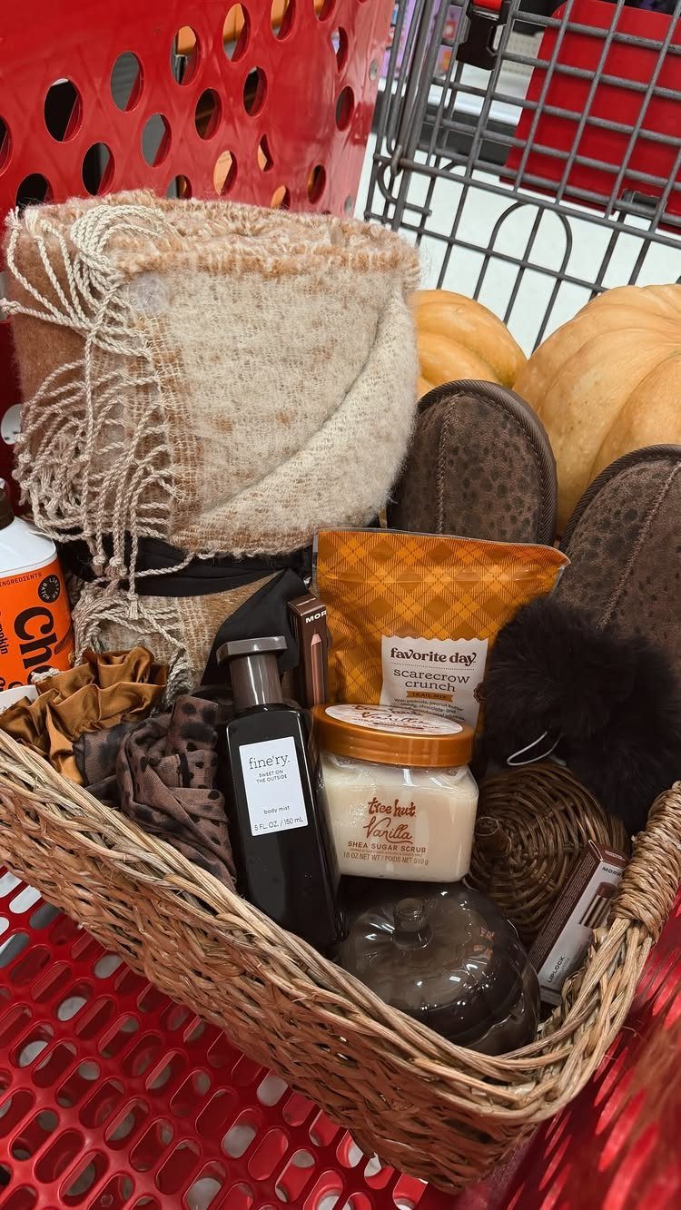 Wicker gift basket with blanket, slippers, and candle inside a red shopping cart