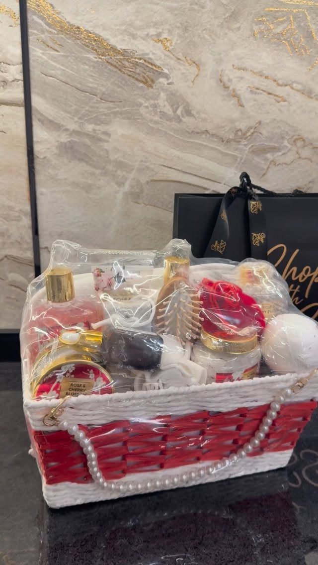 Red and white gift basket filled with beauty products and self-care items.