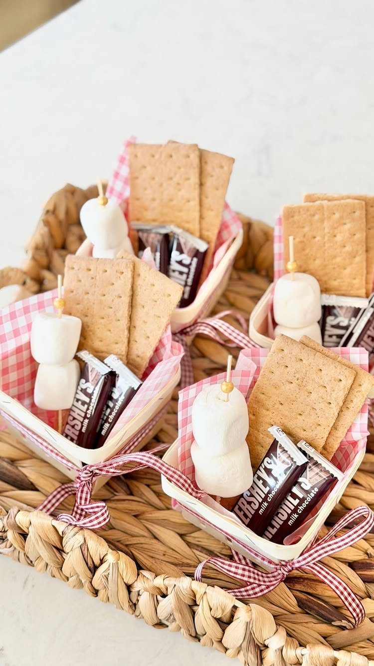 S'mores kits in small checkered baskets with graham crackers, chocolate, and marshmallows.