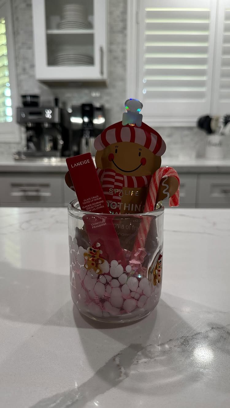 Gingerbread man plush and beauty products in a glass gift arrangement