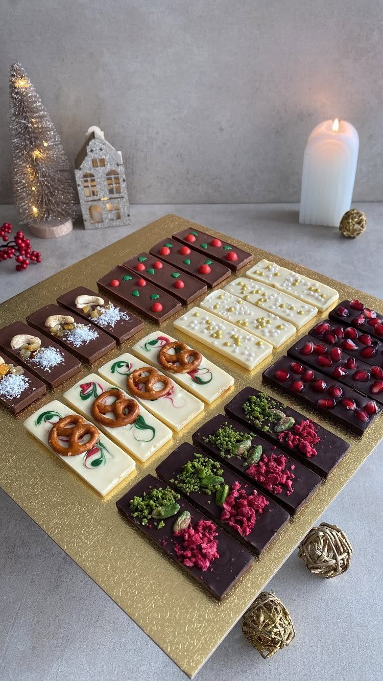 Assorted decorated chocolate bars on a gold tray with Christmas decorations.