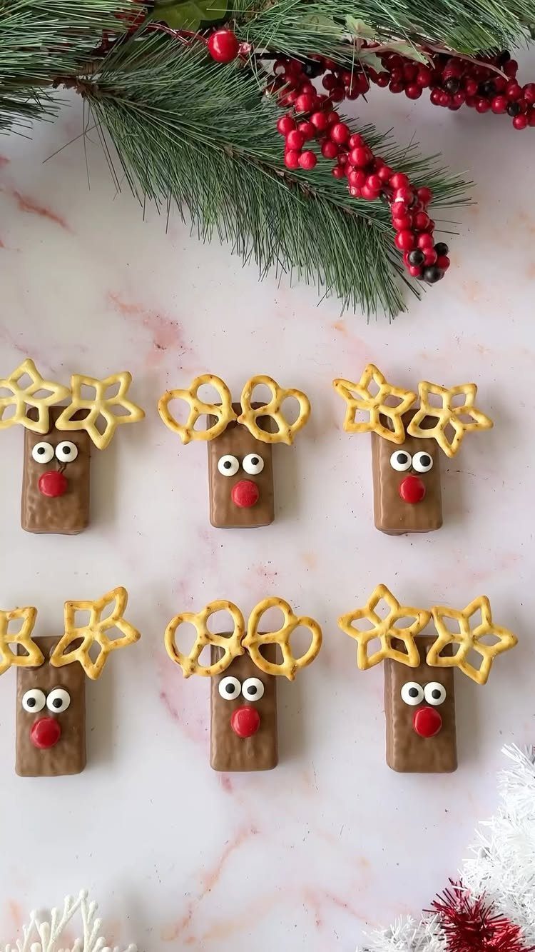 Reindeer treats made of chocolate and pretzels on a marble surface with pine.