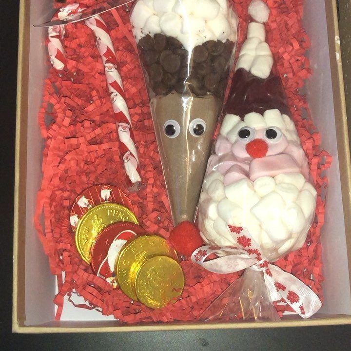 Christmas gift basket with reindeer and snowman treats, gold coins, and candy sticks.