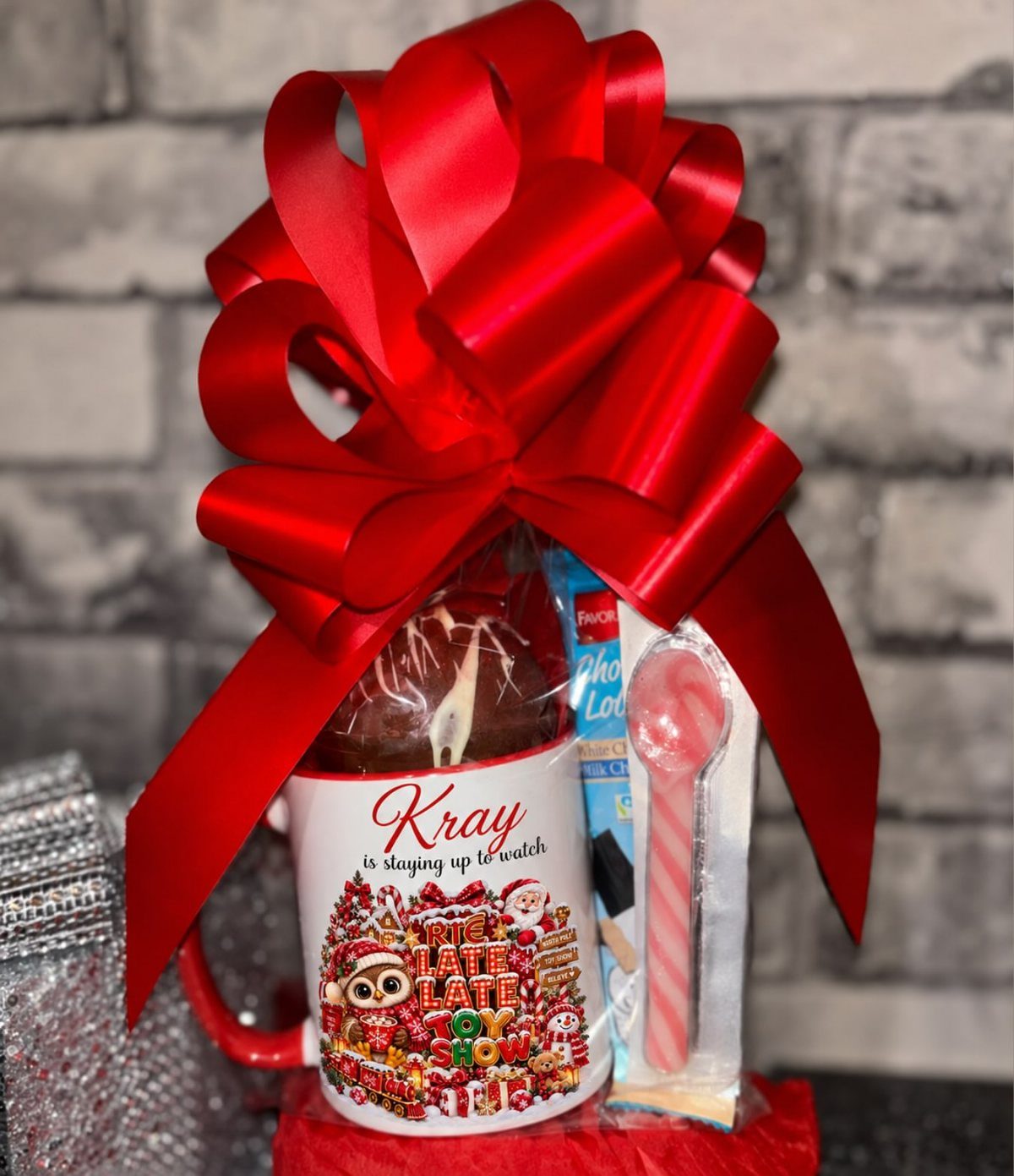 Hot chocolate gift kit with a decorated mug, chocolate bomb, and candy cane.