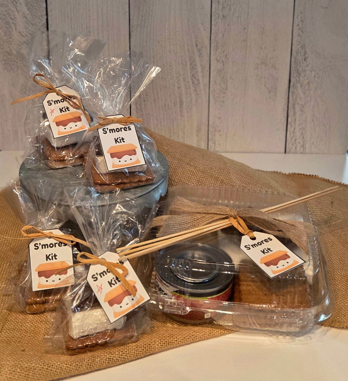 S'mores kits with graham crackers, chocolate, and marshmallows in clear gift packaging.