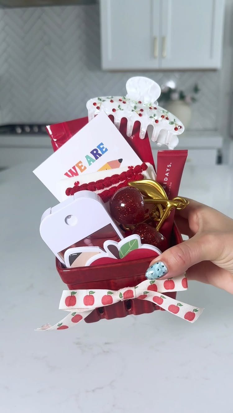 Red berry gift basket for teachers filled with candies, a card, and accessories.