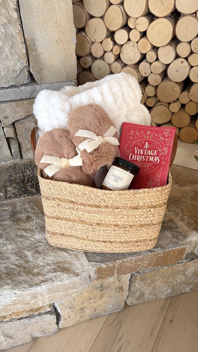 Woven gift basket with white blanket, brown slippers, and red Christmas book.