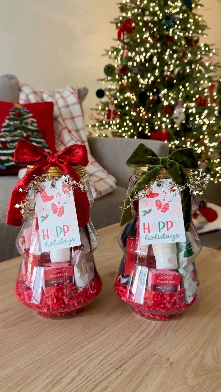 Two holiday gift jars filled with spa products and red shredded paper.