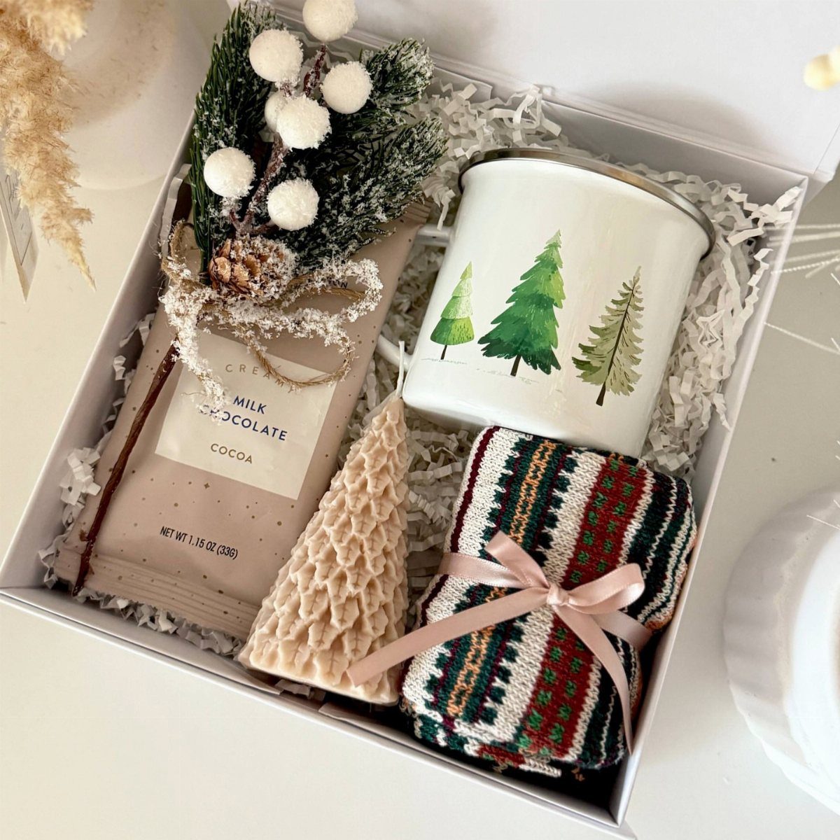 Cozy gift box with chocolate cocoa, pine tree mug, and knit cloth.