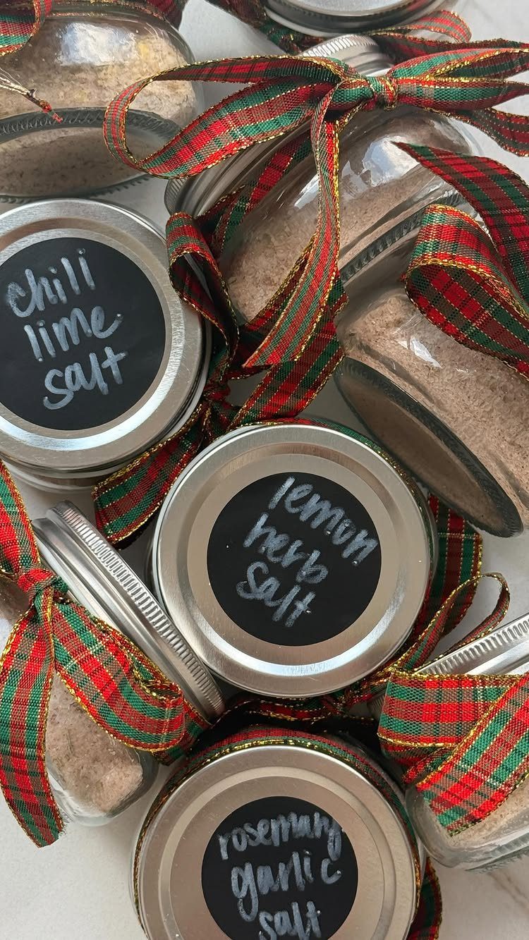 Glass jars of flavored salts with plaid ribbons and handwritten labels.