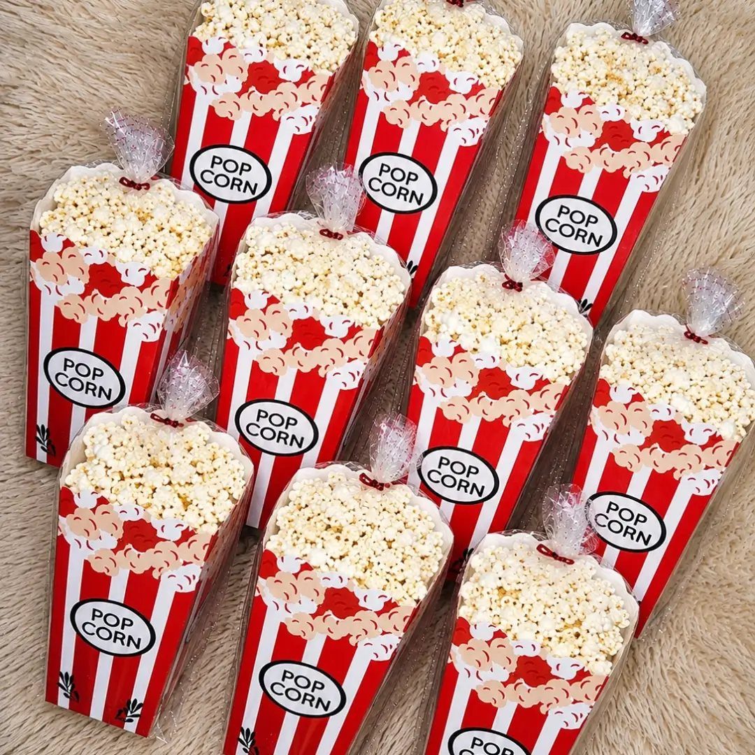 Mini red and white striped popcorn boxes filled with popcorn in clear bags.
