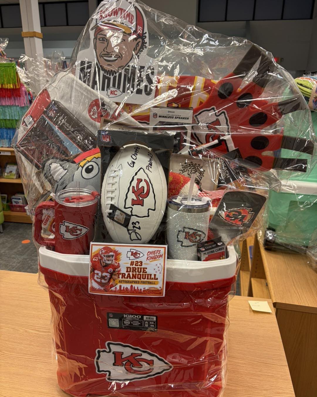 Kansas City Chiefs themed cooler basket filled with football gear and team merchandise.