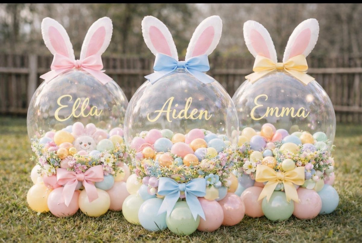Three clear bunny-shaped balloons filled with pastel treats and flowers on green grass.