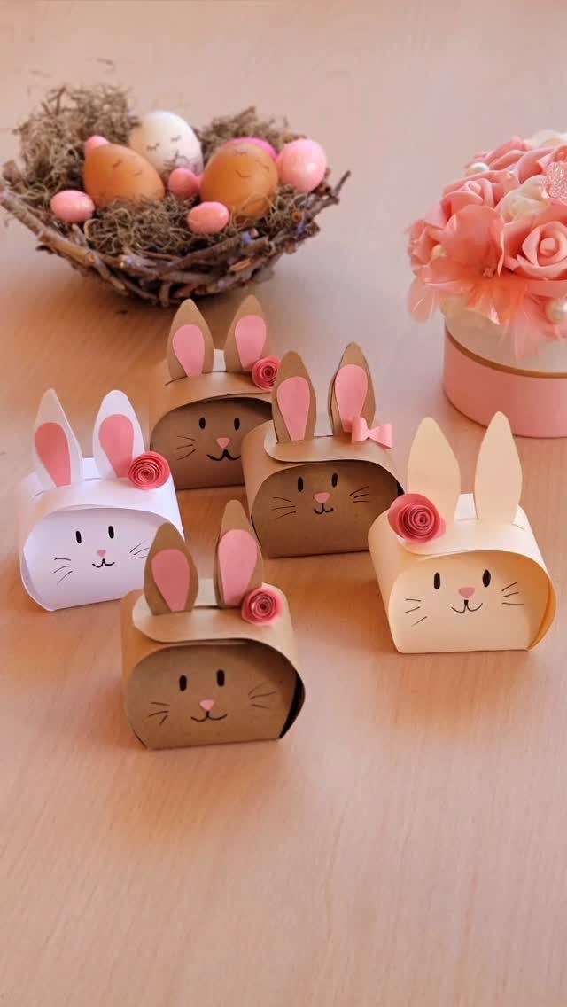 Bunny shaped paper treat boxes with pink flowers and Easter eggs in background