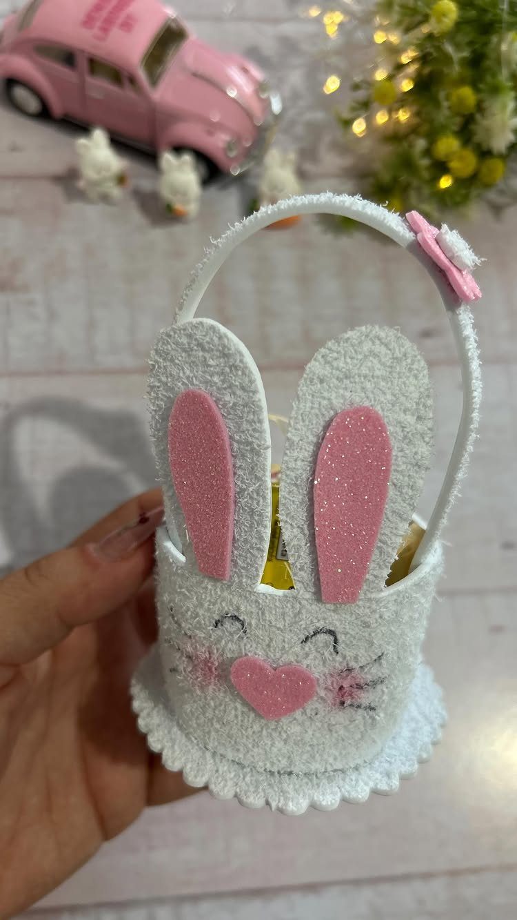 White felt bunny Easter basket with pink glittery ears held in a hand.