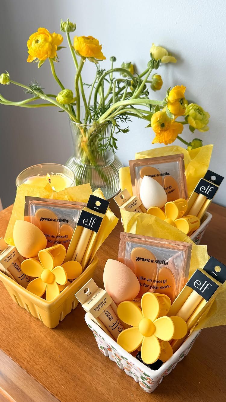 Three yellow Easter baskets filled with makeup products and yellow floral decorations.