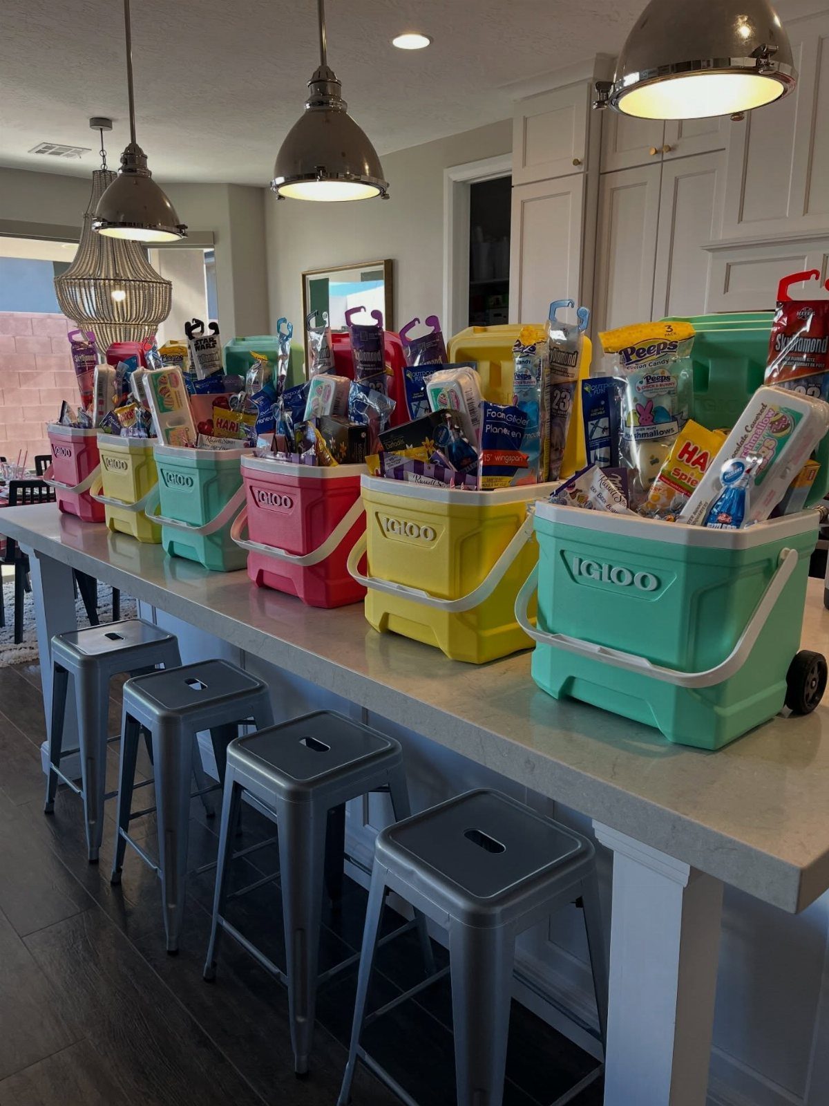 Colorful plastic storage bins filled with candy and snacks on a kitchen counter.