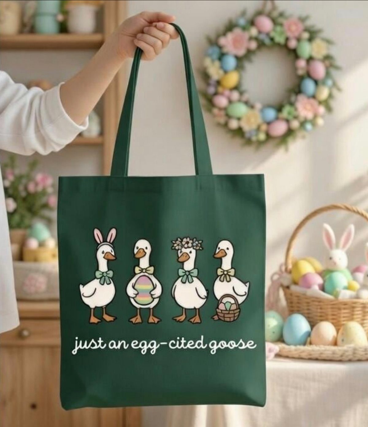 Green reusable tote bag with geese illustration held in front of Easter decorations.