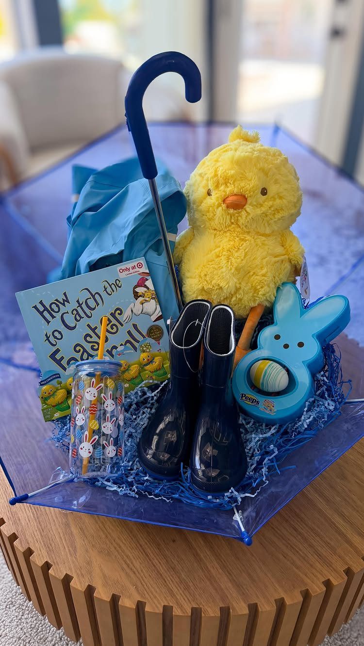 Blue umbrella Easter basket filled with a yellow chick, boots, and themed toys.