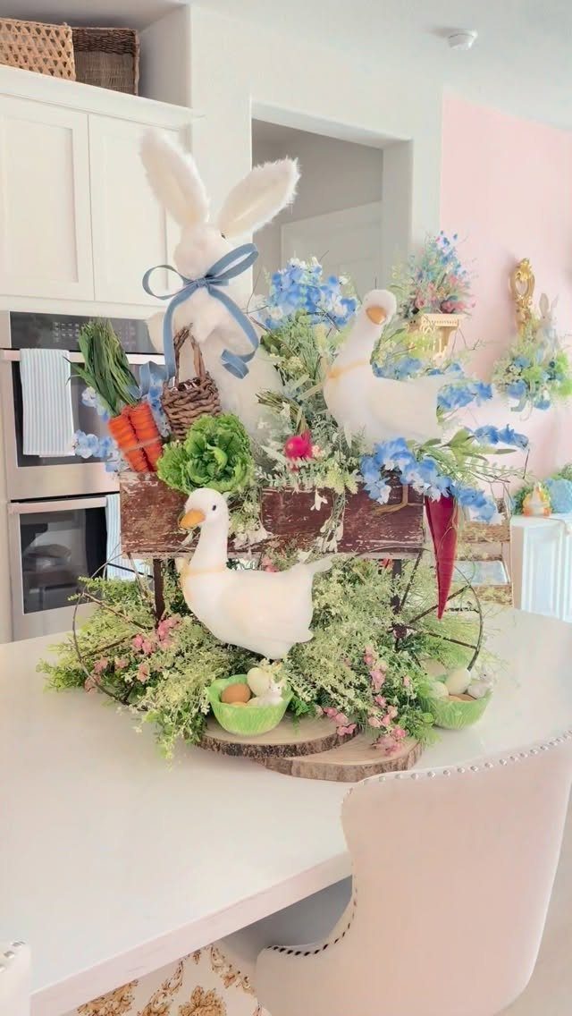 Toy wagon filled with Easter bunny, geese, and colorful spring flowers on table