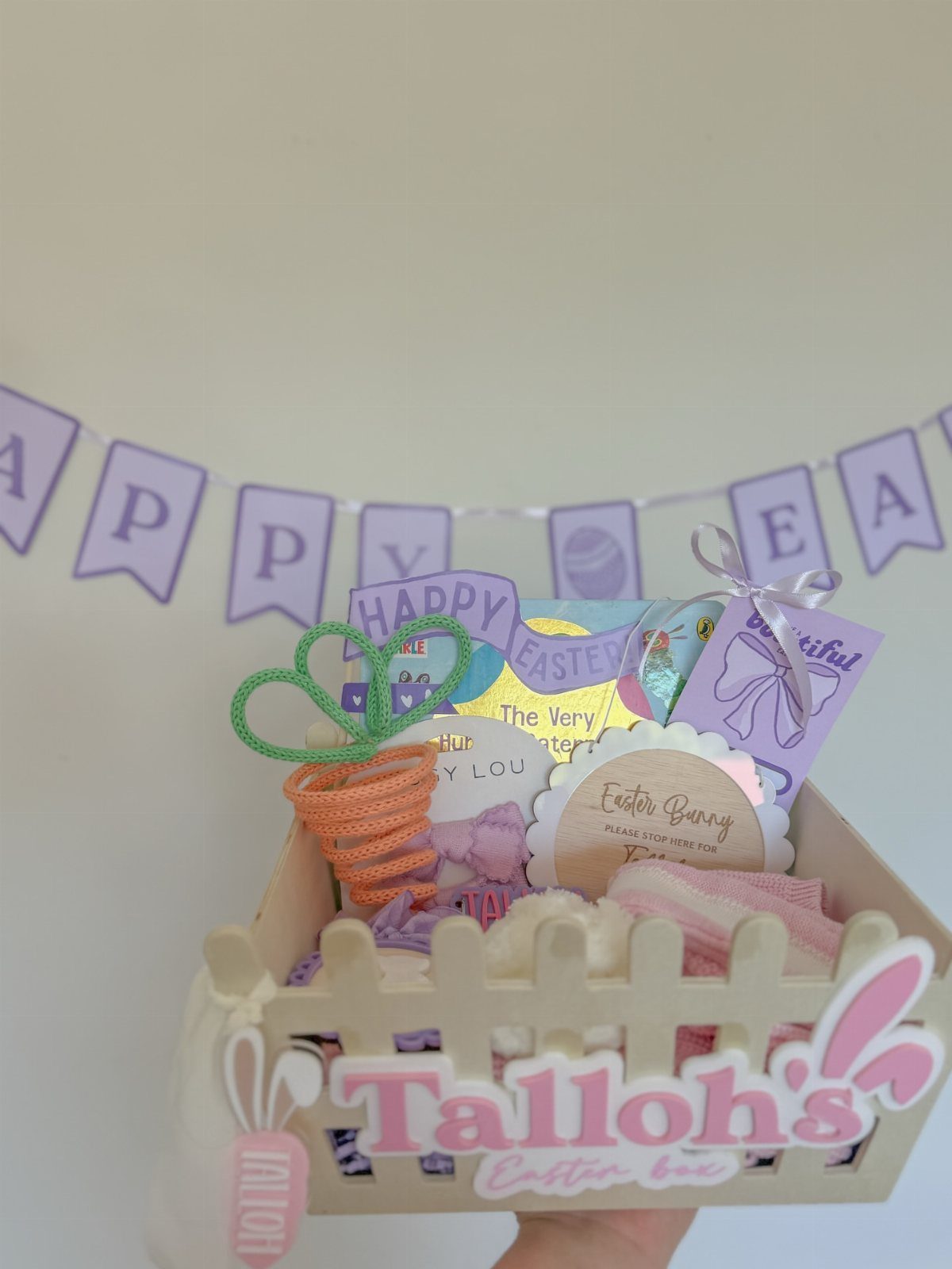 Wooden Easter treat box with picket fence detail and colorful holiday fillers.